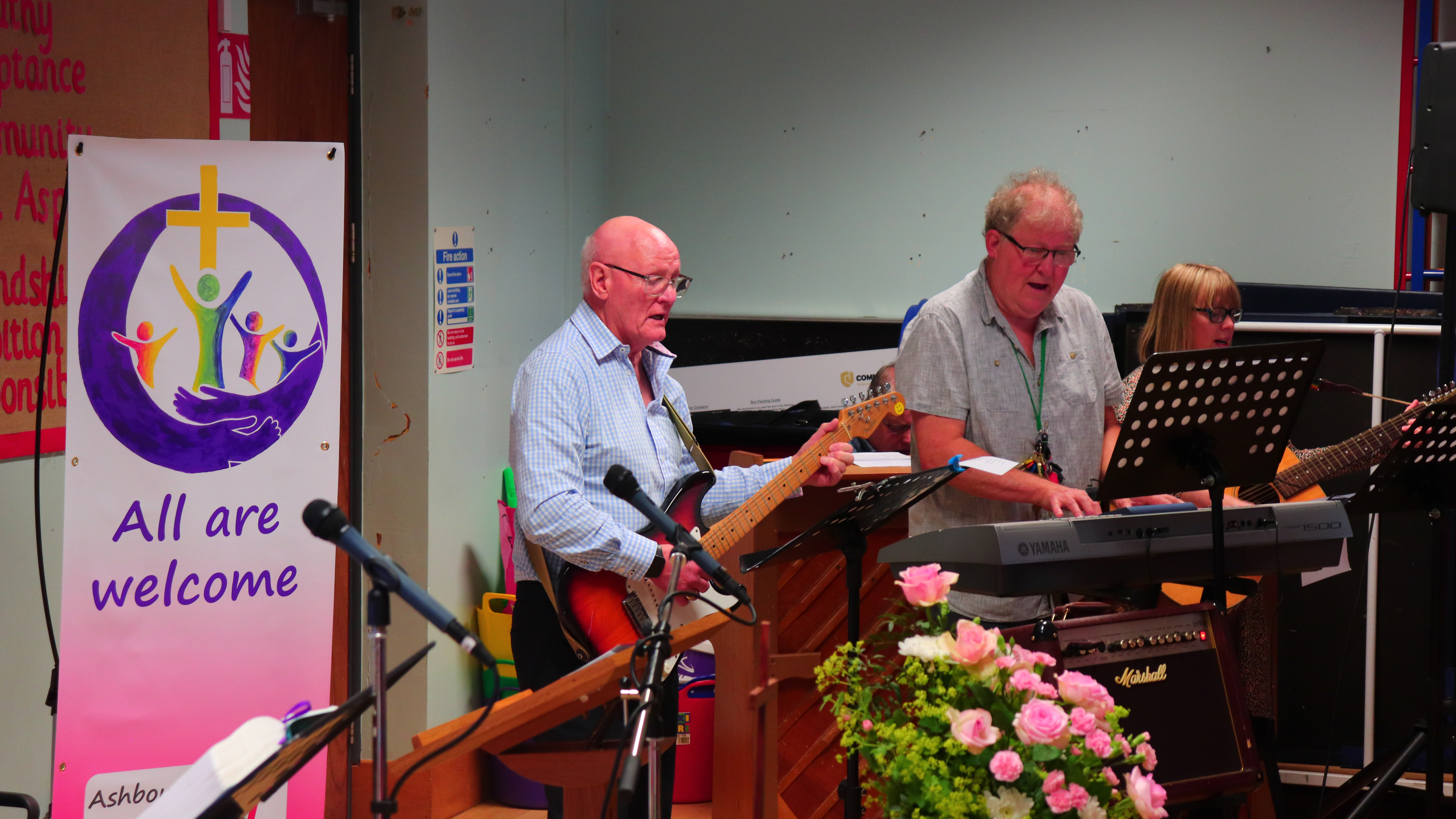 Two musicians playing guitar and singing in church