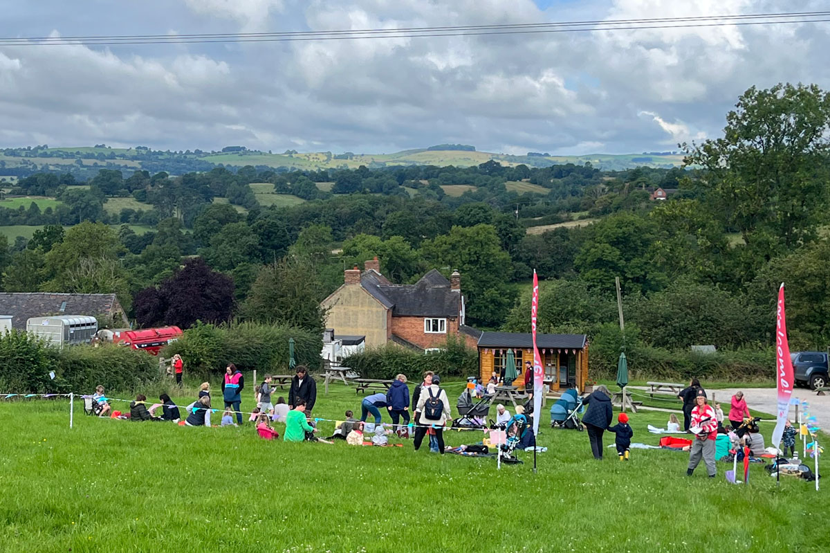 A photo of adults and toddlers in a field