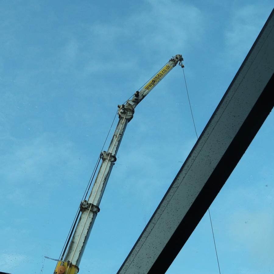 2025-11-19  Crane viewed through partially installed roof glazing.jpg