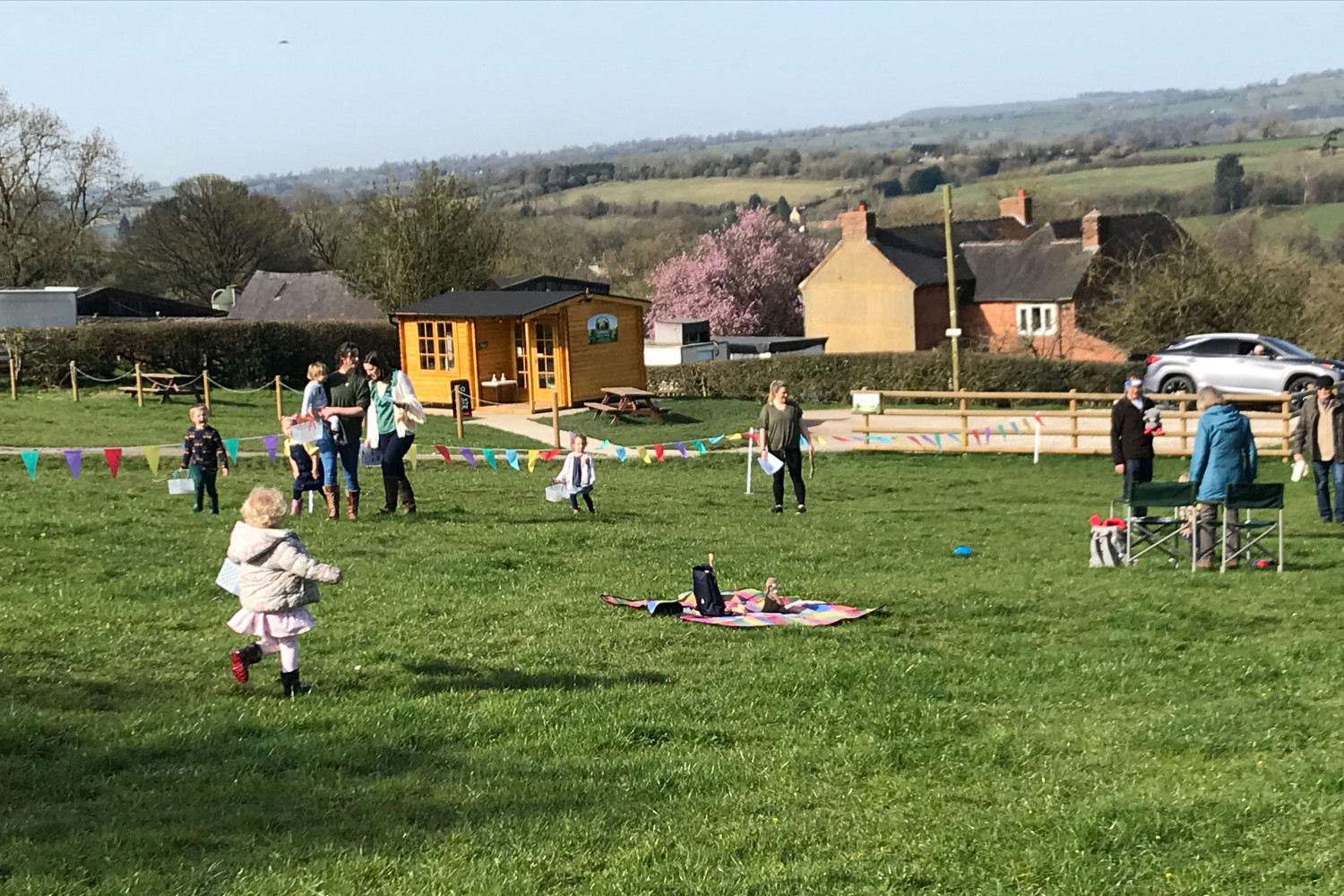 A photo of adults and toddlers in a field