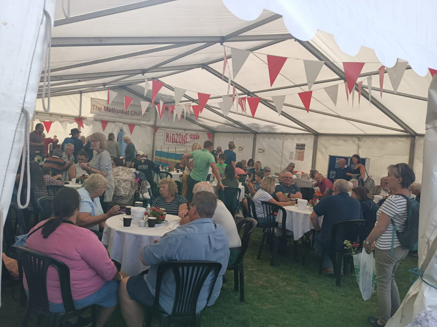 Photo showing the inside of a marquee full of people sat at tables enjoying refreshments