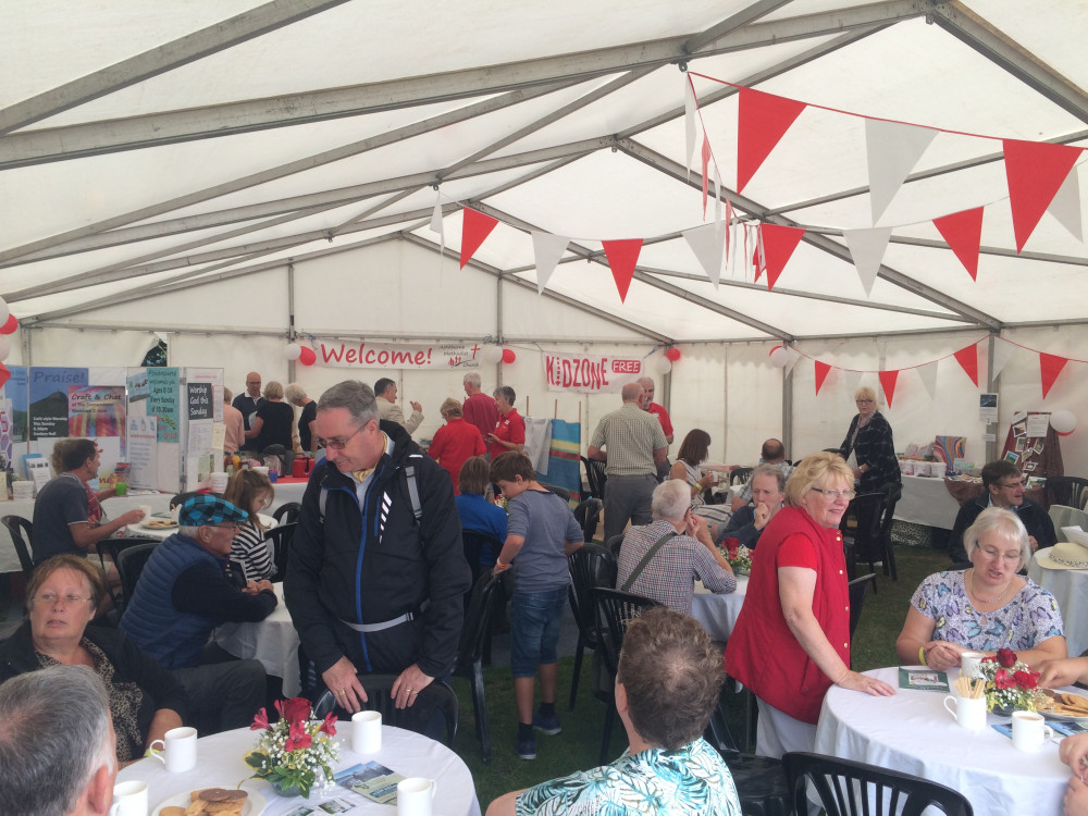 Photo showing the inside of a marquee full of people sat at tables enjoying refreshments